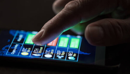 Where can you buy crypto Close-up of a hand selecting cryptocurrency options on a smartphone screen, highlighting digital currencies like bitcoin, ethereum, and others.