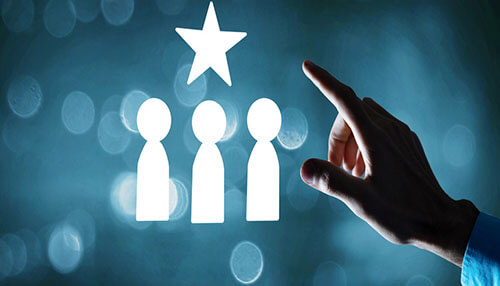 Employee skills assessment - tycoonstory | tycoonstory media A hand pointing to a star above the icons of three people, symbolizing employee skills assessment, customer review, or team recognition.