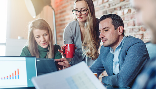 Diversify your investments - tycoonstory | tycoonstory media Pranav arora boca raton: team of professionals working in an office, with pranav arora looking at a tablet with documents and a graph visible on a laptop.