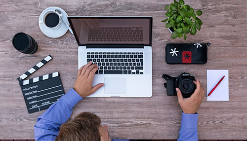 Gimp Content creator using photoshop on laptop while preparing camera visuals and media assets