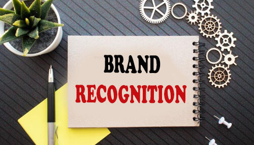 Greater brand recognition and customer base - tycoonstory | tycoonstory media Notebook displaying the words brand recognition with gears and plant on a desk, highlighting the importance of franchising in building brand identity.