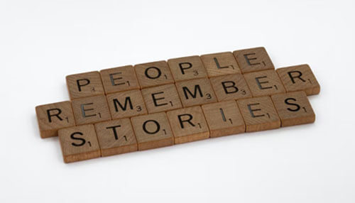 Memorize Memoir message shown with scrabble tiles spelling ‘people remember stories,’ highlighting the power of personal narratives.