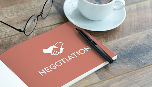 Neuro linguistic programming A notebook with the word'NEGOTIATION' and a handshake icon, symbolizing how Neuro Linguistic Programming (NLP) can enhance negotiation skills at all levels.