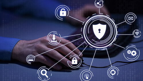 Pci dss - tycoonstory | tycoonstory media Person using a computer with holographic icons of a shield and locks, representing cybersecurity regulations and data protection.