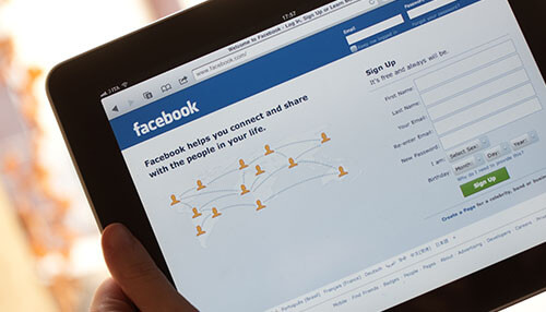 Local clothes producers Tablet showing facebook, a platform used by clothing manufacturers for global marketing and networking.