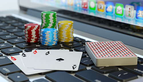 Reasons you should gamble Poker cards, casino chips, and playing cards on a laptop symbolizing reasons you should gamble online.