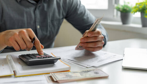 Why is a commercial truck loan calculator necessary A large, modern gold semi-truck with a white trailer driving on a winding, snow-dusted mountain road at sunset. This image shows the type of asset that would require a commercial truck loan calculator.