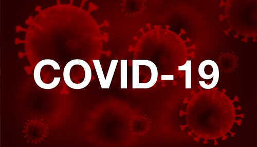 Covid-19 Red background with illustrated COVID-19 virus particles and the text “COVID-19,” representing how the pandemic impacted UK fuel prices.