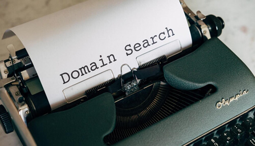 Do your research - tycoonstory | tycoonstory media Typewriter with a sheet of paper showing'Domain Search,' symbolizing the importance of domain research for building a strong personal brand.