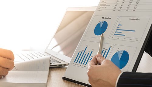 Employ storytelling - tycoonstory | tycoonstory media Professionals poring over market charts and financial data, which mean business analysis; there is a laptop in the background.