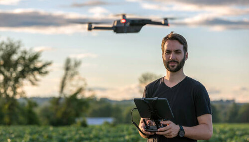 Drone data management budget Drone operator using a controller in an open field, demonstrating real-time drone data management and budget optimization.