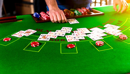 How to beat the best casinos Close-up of a blackjack table with playing cards and poker chips, showing a competitive gaming moment at a casino.