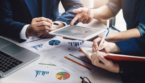 It can increase sales volume Business professionals reviewing data on a tablet, highlighting the role of strategic planning in brand protection and management