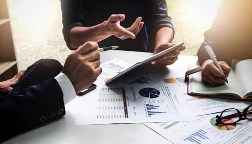 Motivate sales team Business professionals discussing strategies with charts and graphs to increase business revenue.