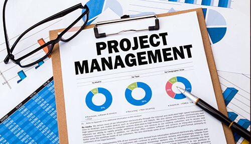 Project management Project management report with pie charts and graphs, highlighting key performance metrics, with a pen and glasses placed on top of the document.