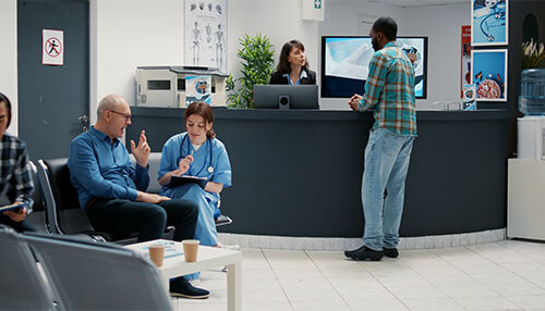 Seating arrangement A busy medical office reception area with a nurse interacting with a patient, and two people sitting in the waiting area, showcasing the functional layout of a reception in a healthcare facility.