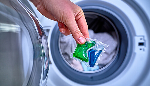 Uses and applications A person placing a laundry detergent pod containing polyvinyl alcohol (pva) into a washing machine, demonstrating the use of pva in cleaning products.