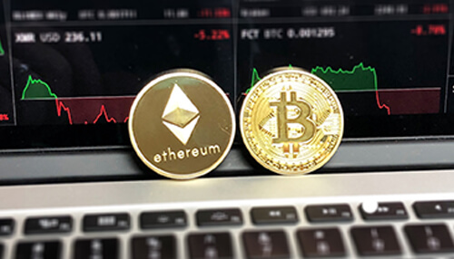 Uses and application of the platform Close-up of ethereum and bitcoin coins, placed on a laptop with cryptocurrency market data in the background.