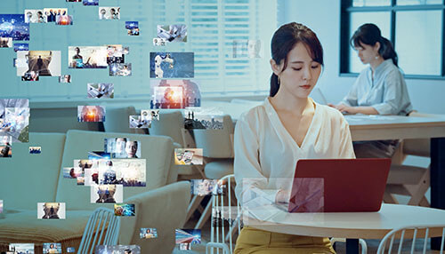 Digital marketing campaigns A professional working on a laptop surrounded by floating media visuals, representing content creation and analytics used in modern digital marketing campaigns.