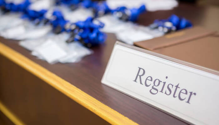 Company registration - tycoonstory | tycoonstory media A registration desk at an event with a sign reading'Register,' representing the process of registering for events related to Foreign Direct Investment.