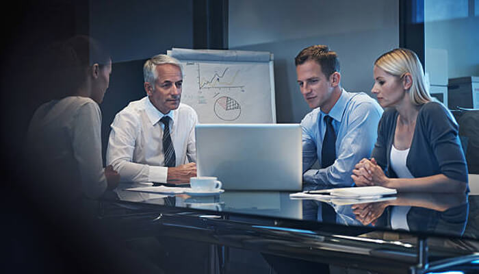 Creating a wide range of potential business models Business team analyzing market data and graphs during a meeting, discussing strategies to address business disruption.