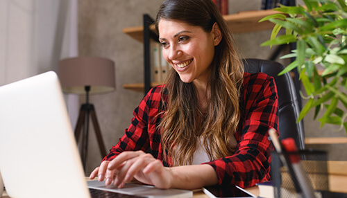 Flexibility Genz entrepreneurs working remotely as a young professional types on a laptop in a creative home office setup.