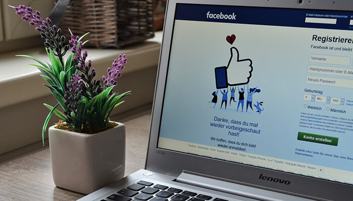 Know when audience is active Facebook sign-up page open on a laptop, featuring a welcoming'thumbs-up' graphic and a message encouraging users to join the social platform, Facebook.