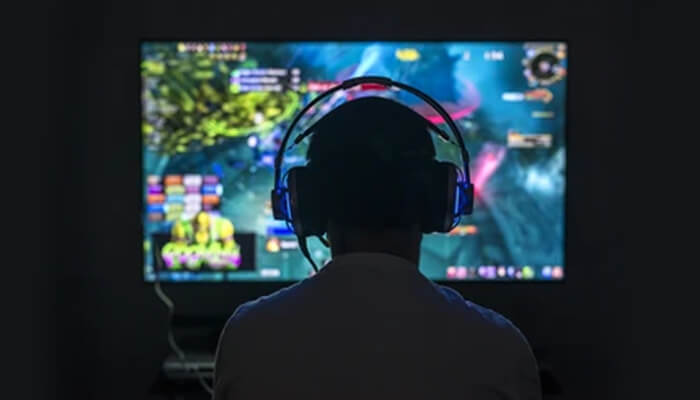 Take the fight to the enemies Gamer playing dota 2 on a large screen with headphones