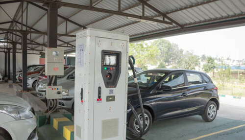 Used vehicles qualify - tycoonstory | tycoonstory media Electric car charging station with a car plugged in, illustrating the notion of tax credit for electric cars.