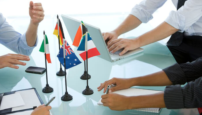 Begin building local relationships A diverse group of professionals collaborating and discussing data during a meeting, displaying teamwork and problem-solving skills.