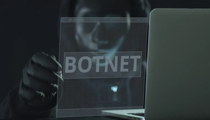 Botnets Dark-themed image showing a hacker with a laptop and the word ‘botnet,’ illustrating business cybersecurity risks and online threats.