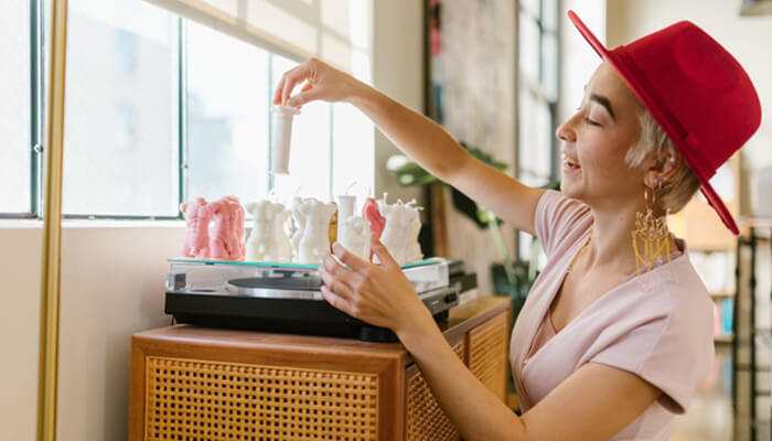 Home businesses Small business owner arranging handcrafted candles and creative products in a bright studio workspace.
