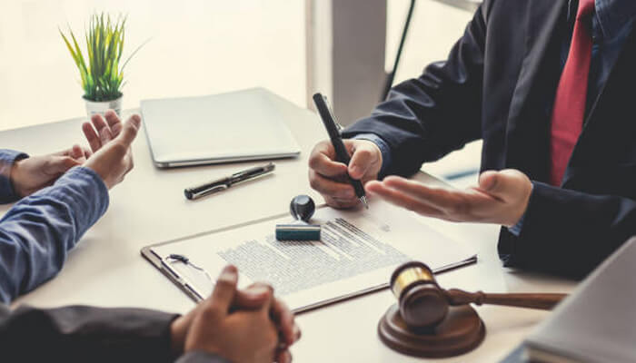 Facts of the lawsuit Business professionals discussing a legal matter at a desk, possibly related to adidas trademark or branding issues.