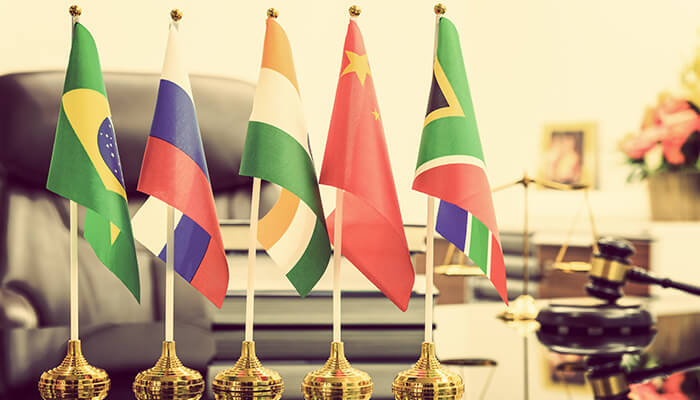 How do the brics countries affect the global economy - tycoonstory | tycoonstory media Flags of brics nations: brazil, russia, india, china, and south africa displayed on flagpoles in a courtroom setting