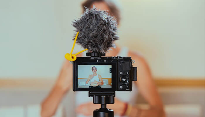 Home businesses Content creator recording a video with a camera and microphone setup for digital marketing and online education.