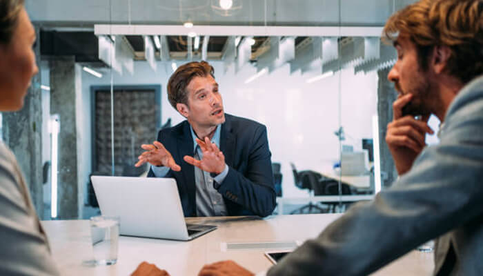 The kind of advice you need A financial advisor discussing investment strategies with clients during a meeting in a modern office