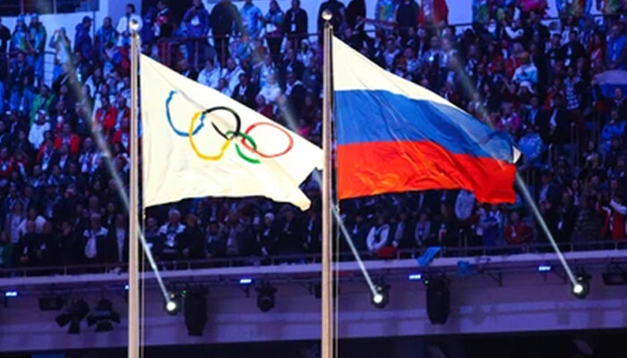 Is the terror somehow acceptable - tycoonstory | tycoonstory media Two flags—one bearing the multi-colored olympic rings and the other the russian tricolor—wave at a sports venue. This represents the central controversy highlighted by zelensky's Ukraine, where the Ukrainian president has argued that any presence of the Russian flag at the Olympics is stained with blood