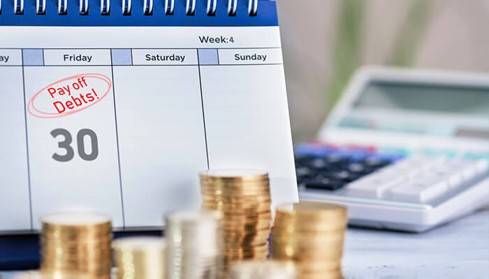 Financial problems Calendar reminder to pay off debts with stacked coins symbolizing solutions to financial problems