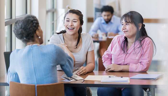 Steps to apply for the womens business loan and the documents required for it A group of people, including a consultant, discussing loan details in a collaborative setting, emphasizing a team approach to financial discussions.