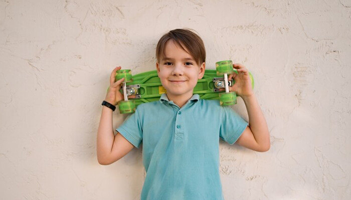 22 inches skateboard A young boy proudly holding his new skateboard, symbolizing the excitement of receiving gifts that encourage personal growth and outdoor activities.