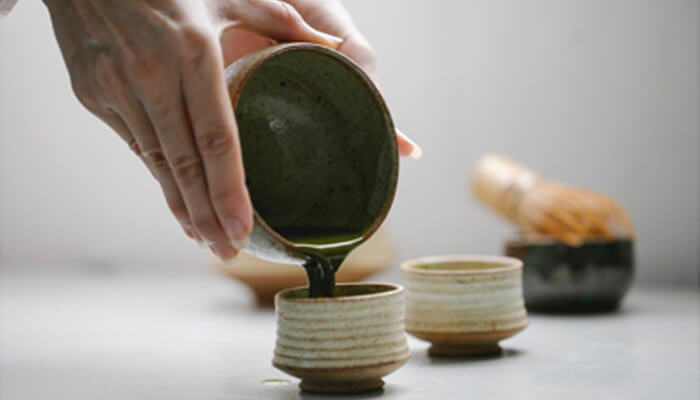 Are black extra strength shots safe Mit45 ceremonial tea being poured into traditional ceramic cups, showcasing a mindful wellness ritual