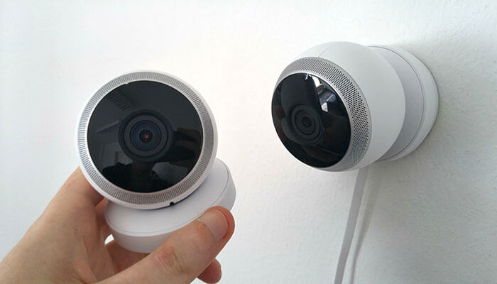 Ptz cameras A hand holding a modern wireless security camera, showcasing the compact design and functionality for home or business surveillance