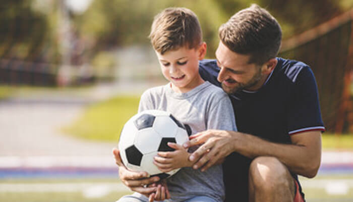 Football A father and son enjoying quality time together, with the father gifting a soccer ball, representing the bond built through meaningful gifts.