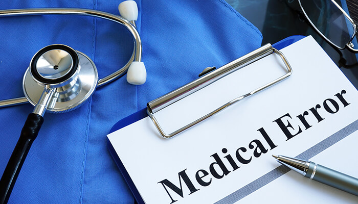 Medication errors Medical malpractice: a clipboard with a'Medical Error' document, stethoscope, and pen.