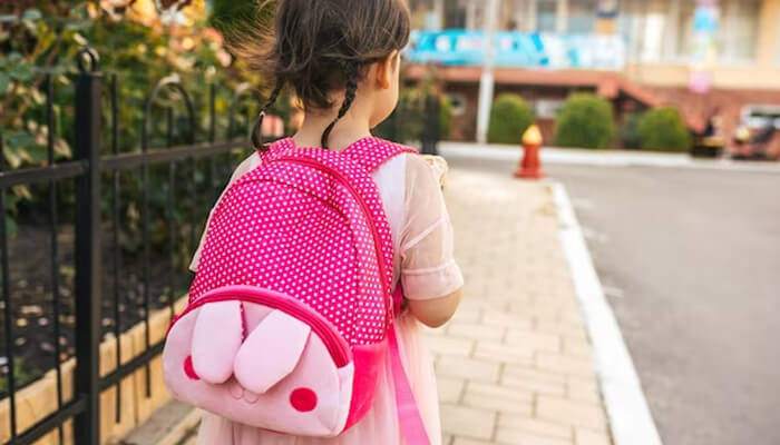 Mini backpack Child wearing a cute pink backpack while walking outdoors, representing everyday school and travel essentials.