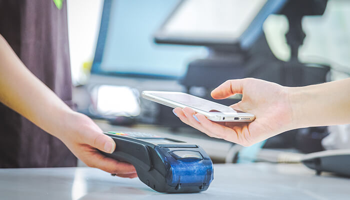 Support multiple types of payment A person completing a transaction via mobile pos system at a retail store, showcasing the ease of contactless payments with smartphones.