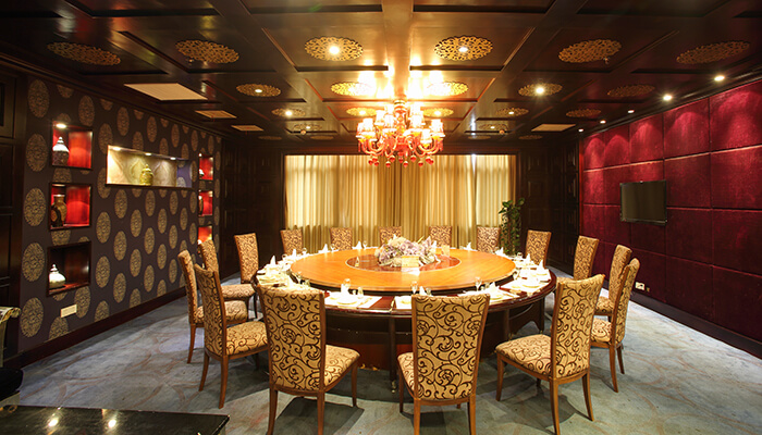 The different elements of restaurant interior design that can make a difference Luxurious private dining room with rich red walls, ornate chairs, and a grand chandelier, showcasing intricate interior design for an exclusive and upscale experience.