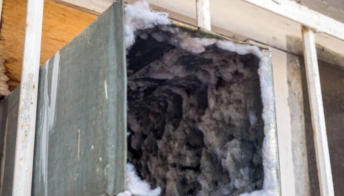 When cleaning the accumulated winter dirt Dirty residential air duct covered in dust and debris, showing the need for professional duct cleaning services.