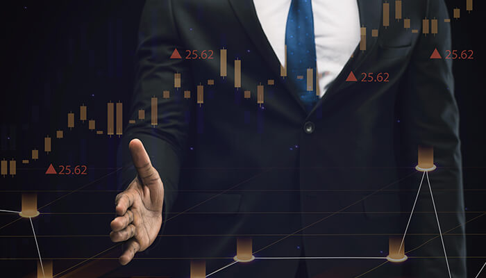 Actuarial jobs Image of a professional in a suit standing against a background of financial data and stock charts, symbolizing the career opportunities in actuarial jobs and data analysis.
