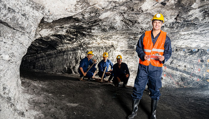 Drawbacks of hosted mining for small-scale miners A group of mining professionals standing in a mine, showcasing the collaborative work behind mining operations, such as those that power hosted mining solutions.